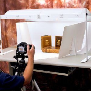 man taking picture of books in product photography lightbox